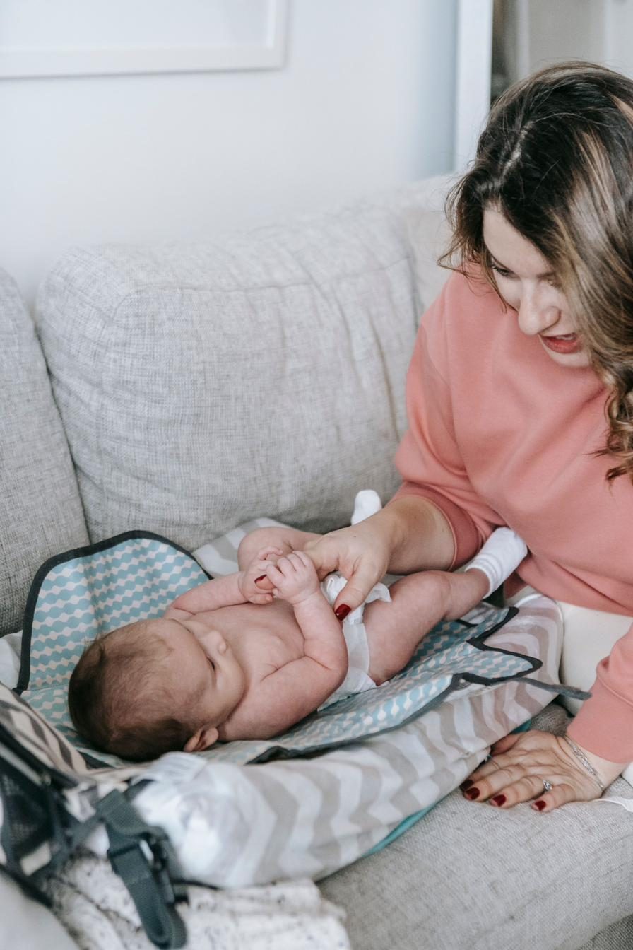 Mother smiling with her baby during a diaper change